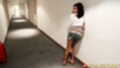 Standing on hotel corridor wearing shorts