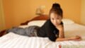 Lying on her side wearing jeans