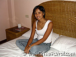 Filipina Women On Bed Wearing White Top And Jeans