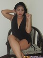 Sitting cross legged on chair in black dress