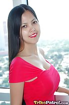 Long hair flowing down her back standing at window wearing red dress