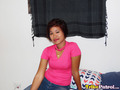 Sitting on bed wearing pink top
